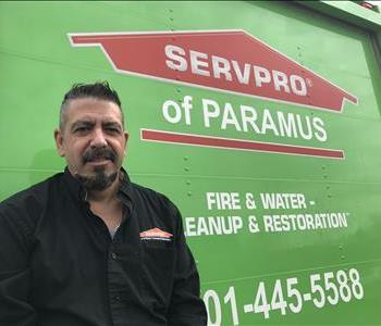A employee standing in front of a SERVPRO vehicle. 