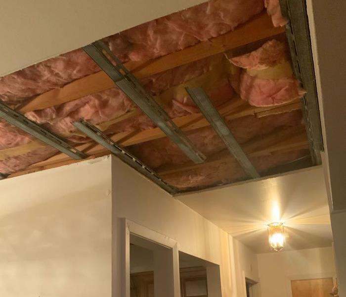Kitchen ceiling with insulation visible through hole