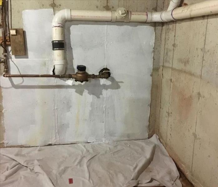 Basement wall with plumbing pipes