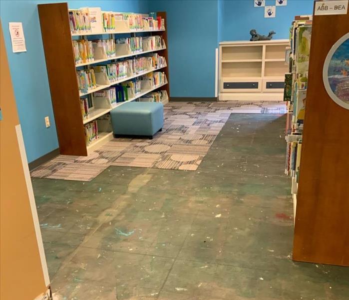 Library with removed carpet in front of bookcases