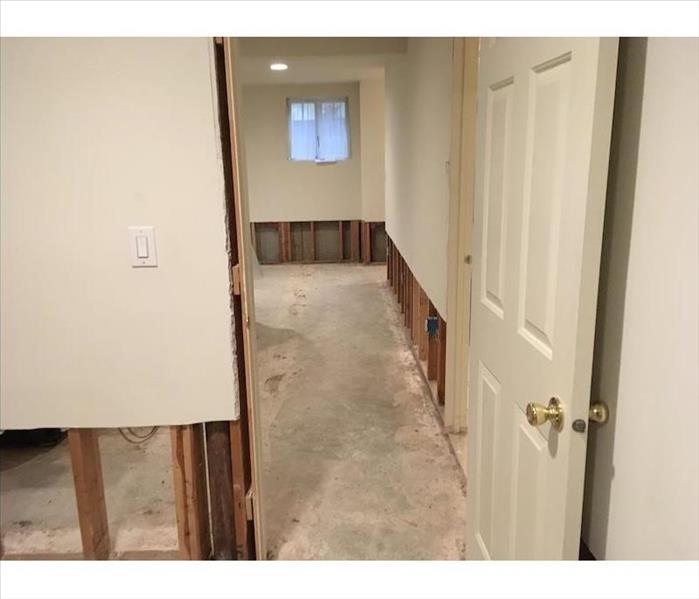 Room with sheetrock cut away around the floor joists and subfloor showing