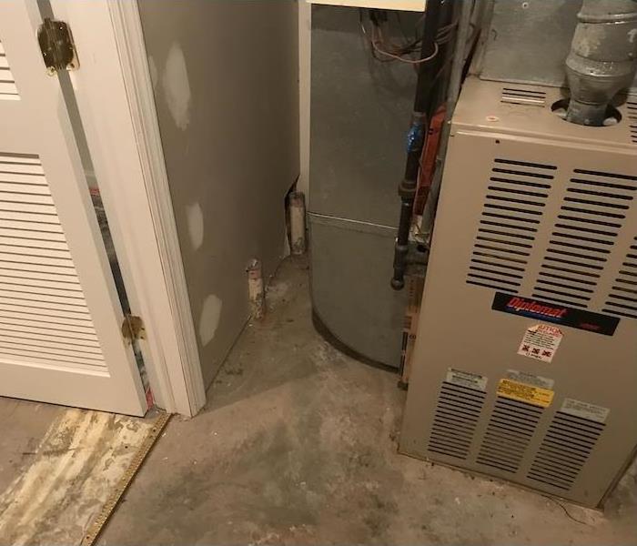 Utility room with furnace and carpet removed from the doorway