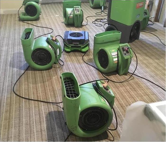 Our air movers and dehumidifiers working to dry the carpet in this property